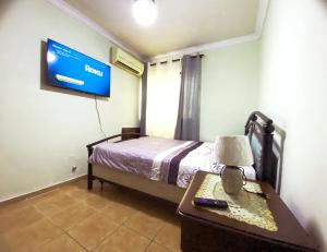 a bedroom with a bed and a table and a tv at Amplio apartamento en Gazcue SDQ in Santo Domingo