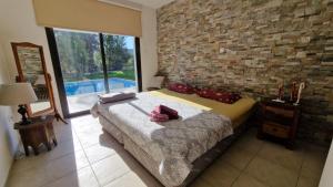 a bedroom with a bed and a brick wall at The Stone Villa in Pissouri