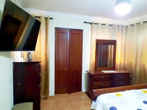 a bedroom with a bed and a dresser and a television at Amplio apartamento en Gazcue SDQ in Santo Domingo