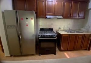 a kitchen with a stainless steel refrigerator and a stove at Amplio apartamento en Gazcue SDQ in Santo Domingo