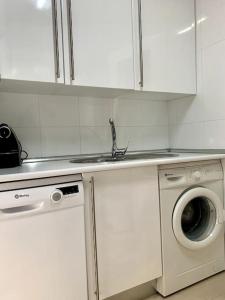 a kitchen with a sink and a washing machine at Lotus (garaje y wifi) in Ávila