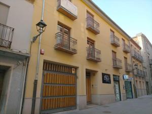 a yellow building with a gate and a garage at Lotus (garaje y wifi) in Ávila