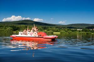 a group of people sitting in a red boat on the water at Landgasthof "Altes Haus" in Waldmünchen