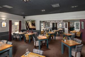 a dining room with tables and chairs in a restaurant at The World's End - Northampton in Northampton