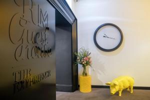 a yellow pig standing in front of a door with a clock at RM The Experience - Small Portuguese Hotels in Setúbal