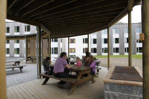 eine Gruppe von Menschen, die auf einem Picknicktisch sitzen in der Unterkunft Førde Sommarhotell in Førde