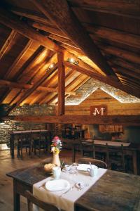 comedor con techos de madera, mesas y sillas en Maison Farinet, en Saint-Rhémy-en-Bosses