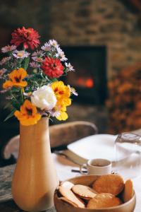 un vase rempli de fleurs et d'une assiette de pain dans l'établissement Maison Farinet, à Saint-Rhémy-en-Bosses