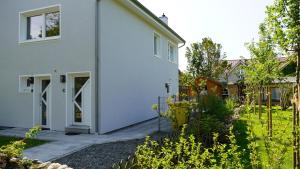 une maison blanche avec ses portes s'ouvrant dans une cour dans l'établissement La Mer Whg 01, à Wyk auf Föhr