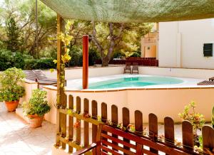 bañera de hidromasaje en un patio con valla en Apartamentos El Pino - Formentera Break en Es Caló