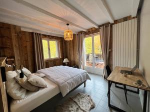 sypialnia z łóżkiem, stołem i oknem w obiekcie LES CIMES BLANCHES CLEDICIHOME Chalet 10 pers SPA & Grand terrain 4 MINUTES DES PISTES w mieście La Bresse