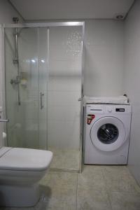 a bathroom with a toilet and a washing machine at Casa Fragosa - Alojamento local in Póvoa de Varzim