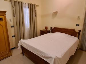 a bedroom with a bed and a window with curtains at Senmut Luxory Rooms in Luxor