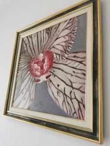 a framed painting of a flower on a wall at Apartament incantator Iasi Copou in Iaşi