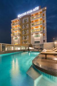 ein Hotel mit einem Pool vor einem Gebäude in der Unterkunft Riche Hua Hin Hotel - SHA Plus in Hua Hin