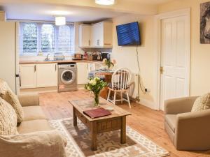 a living room with a table and a kitchen at South Wing Coldharbour Park Farm in Rake