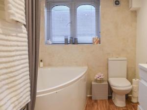 a bathroom with a white tub and a toilet at South Wing Coldharbour Park Farm in Rake