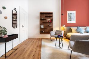 ein Wohnzimmer mit einem Sofa und einem Stuhl in der Unterkunft ipartment Berlin Kurfürstendamm in Berlin