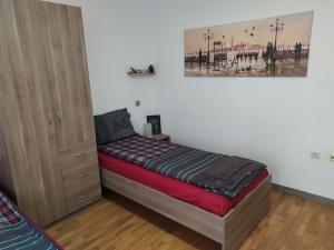a small bedroom with a bed and a cabinet at Apartament Bogoslovovi in Varna City