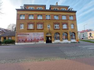 um grande edifício laranja com um sinal nele em Kamienica1924 em Szczecinek