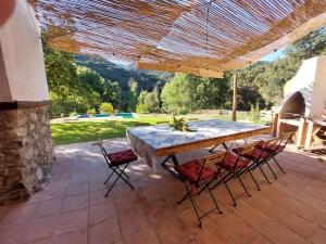 a wooden table and chairs on a patio at Casa Barranco in Júzcar