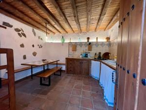 una cocina con una mesa y un banco. en Casa Barranco, en Júzcar