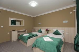 twee bedden in een kamer met groene en witte lakens bij PENSIUNE RESTAURANT LIANA in Mehadia