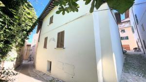 斯波萊托的住宿－traditional town house central Spoleto - car unnecessary - wifi - sleeps 10，白色的建筑,在街上有窗户