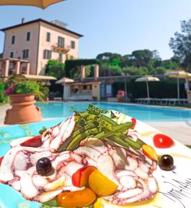 um prato de comida numa mesa ao lado de uma piscina em Domus Volumnia Country House em Perugia