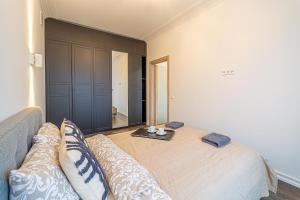 um quarto com uma cama, um sofá e um espelho em Žalgiris arena apartment with AC em Kaunas