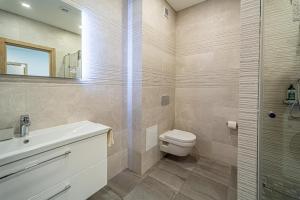 a bathroom with a toilet and a sink and a shower at Žalgiris arena apartment with AC in Kaunas +13 photos