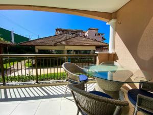 a patio with a glass table and chairs on a balcony at Beverly Hills por Be My Guest in Aquiraz