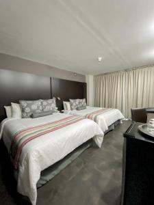 pokój hotelowy z 2 łóżkami i stołem w obiekcie Tibisay Hotel Boutique Mérida w mieście Mérida