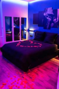 科爾貝埃松的住宿－BLUE NIGHT - Jacuzzi - Bord de Seine，一间卧室配有一张黑色床和紫色灯