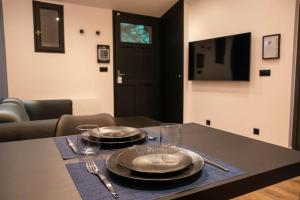 una mesa con platos y vasos encima en BLUE NIGHT - Jacuzzi - Bord de Seine en Corbeil-Essonnes