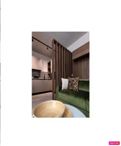 uma sala de estar com um sofá verde e uma mesa em LagoC0C00N - Colazione - 300m stazione - 800m lago em Desenzano del Garda