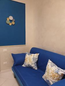 a blue couch with two pillows in a room at Le case di Grazia in Gaeta