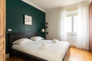 - une chambre avec un grand lit blanc et un mur vert dans l'établissement DIFY Central - Bellecour, à Lyon