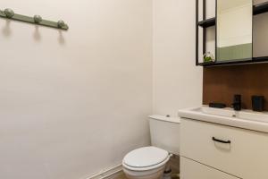 La salle de bains blanche est pourvue de toilettes et d'un lavabo. dans l'établissement DIFY Central - Bellecour, à Lyon