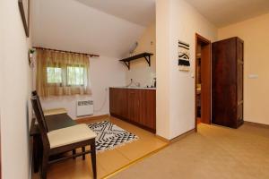 uma cozinha com uma mesa e uma cadeira num quarto em Конна база и Къща за гости Дворене em Razlog
