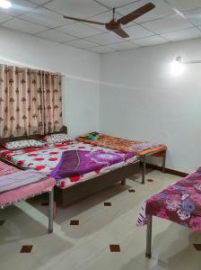 a bedroom with two beds and a ceiling at Gir Ganesh Farm & Resort in Sasan Gir