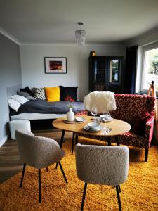 a living room with a couch and a table and chairs at Dagmars Apartment in Steinwenden