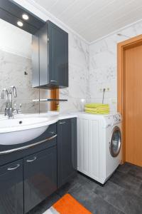 a kitchen with a washing machine and a sink at Ferienwohnung Theesfeld in Nenndorf