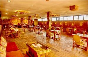 a restaurant with wooden floors and tables and chairs at Hotel Greenwich in Kigali