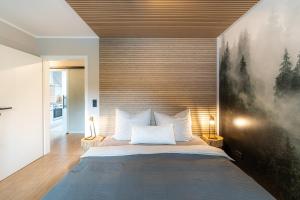 - une chambre avec un grand lit orné d'une peinture murale dans l'établissement Waldbewohner Apartments / Fuchs, à Ilsenburg