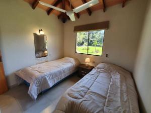 1 dormitorio con 2 camas y ventana en Casa con Piscina, Quincho, Cancha de Futbol/Volley, en San Bernardino