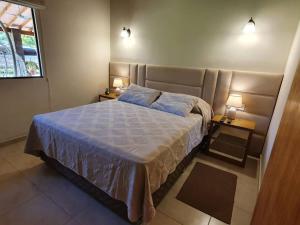 um quarto com uma cama grande e 2 mesas de cabeceira em Casa con Piscina, Quincho, Cancha de Futbol/Volley em San Bernardino