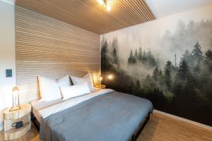 - une chambre avec un lit orné d'une peinture murale dans l'établissement Waldbewohner Apartments / Fuchs, à Ilsenburg