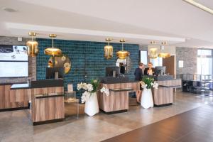 a lobby of a hotel with two women standing at the counter at Thalazur Cabourg - Hôtel & Spa in Cabourg