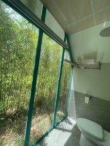 a bathroom with a toilet in front of a window at Paradiso Homestay Mangden in Kon Von Kla